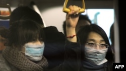 Njerëzit në kryeqytetin Pekin mbrohen kundër gripit duke bartur maska