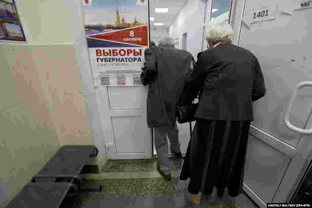 An elderly couple arrives to vote at a polling station during local and regional elections, in St. Petersburg.