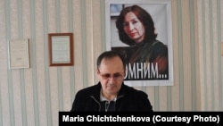 Оюб Титиев на фоне портрета убитой в Чечне коллеги Натальи Эстемировой