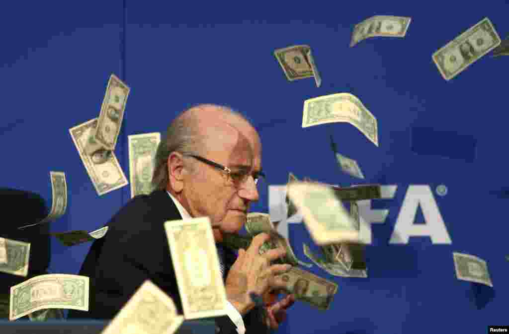 A British comedian, Lee Nelson (not shown), throws banknotes at FIFA President Sepp Blatter as he arrives for a news conference after a FIFA Executive Committee meeting at FIFA headquarters in Zurich. World football's troubled governing body will vote for a new president, to replace Blatter, at a special congress to be held on February 26 in Zurich. (Reuters/Arnd Wiegmann)