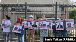 Участники акции у здания представительства ООН с портретами людей, которых правозащитники относят к политзаключенным. 7 августа 2019 года.