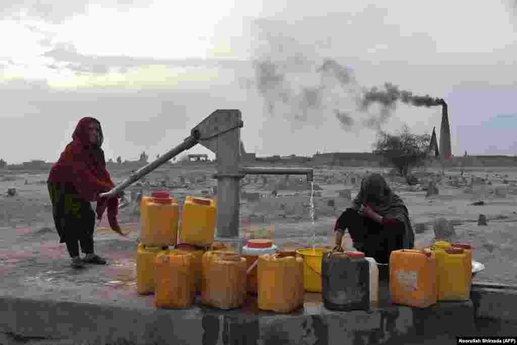 Women collect water from a pump on the outskirts of Jalalabad, Afghanistan. (AFP/Noorullah Shirzada)