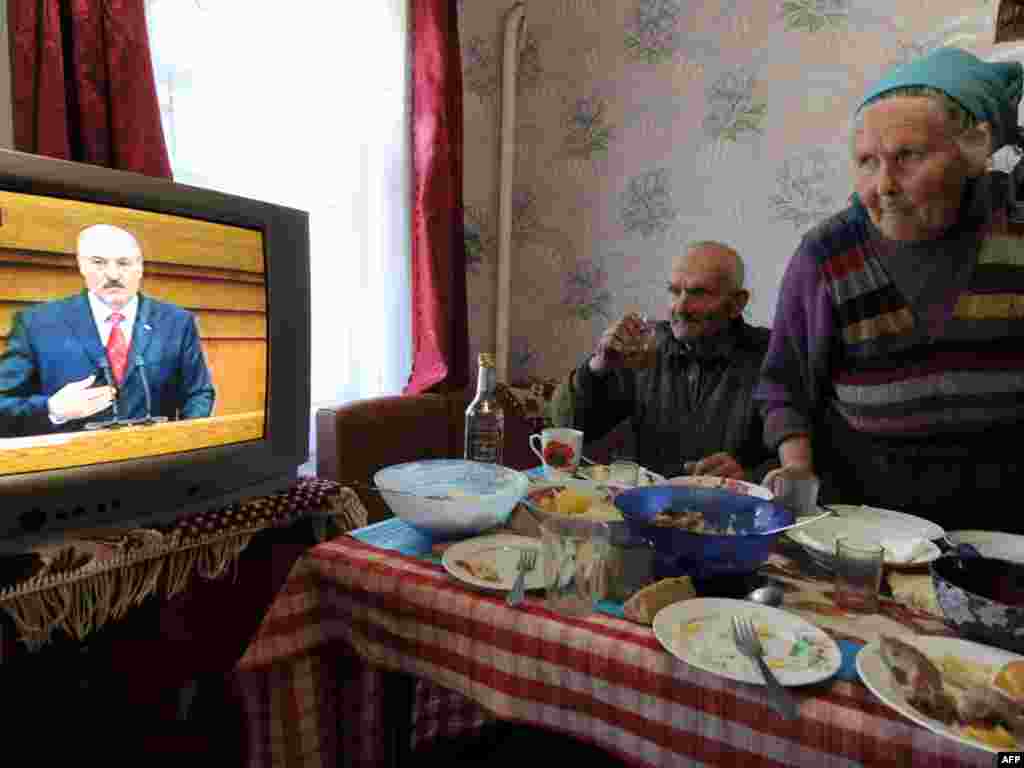 Білоруське подружжя дивиться щорічне звернення президента Олександра Лукашенка, село Рудаков, що у зоні відчуження Чорнобильської АЕС, 21 квітня.Photo by Viktor Drachev for AFP