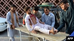 Volunteers carry an injured man on a stretcher to a hospital following a suicide bomb attack in Jalalabad on June 16.