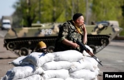 Український солдат курить на контрольно-пропускному пункті в селі Малинівка, на схід від Слов'янська, квітень 2014 року