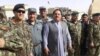 FILE: Abdul Jabar Qahraman surrounded by Afghan military and police officers in Helmand Province.