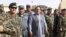 FILE: Abdul Jabar Qahraman surrounded by Afghan military and police officers in Helmand Province.