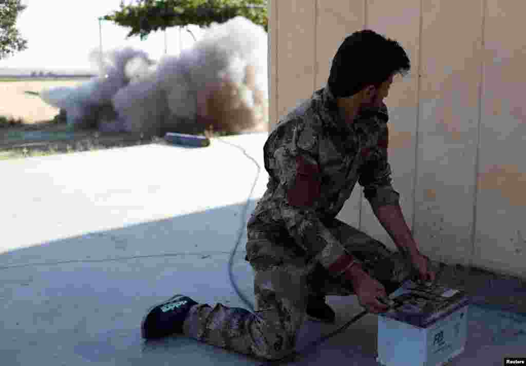 Syria -- A Kurdish fighter from the People's Protection Units (YPG) fires a rocket in Raqqa, June 15, 2017