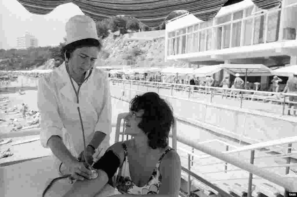 A beachside nurse at the Ukraina sanatorium perfoms a check-up on a vacationer from Kabardino-Balkaria in 1977.&nbsp;