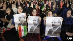 Tehranda seçki kampaniyası zamanı prezidentliyə namizəd Qalibafın tərəfdarları onun şəkillərini tuturlar. 2017