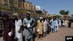 Afghan refugees wait for their registration at the UNHCR repatriation center on the outskirts of Peshawar on September 7.