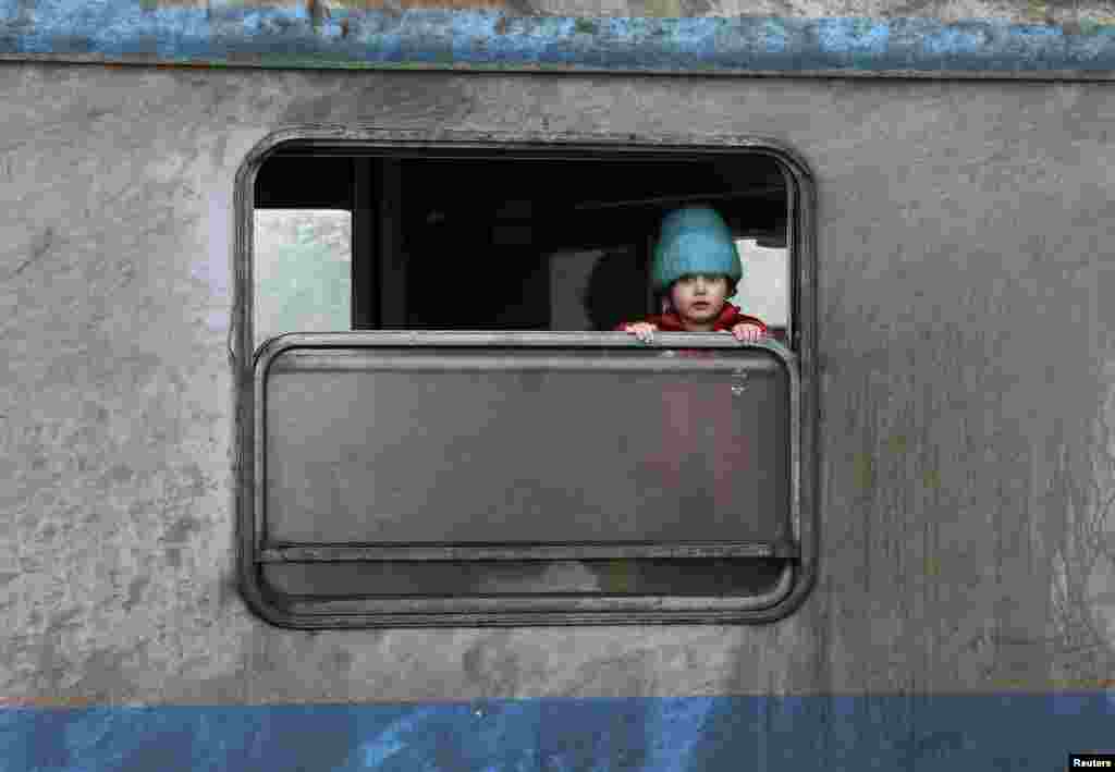 A migrant child looks out of a window at a train station in the town of Sid, Serbia. (Reuters/Marko Djurica)