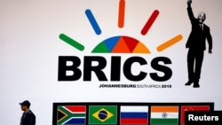 A police officer walks past a billboard outside the BRICS summit meeting in Johannesburg, South Africa, on July 25.