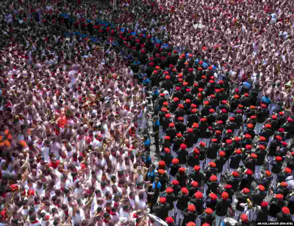 Police hold back revelers as the Festival of San Fermin begins in Pamplona in northern Spain. Hundreds of thousands of visitors from all over the world attend the fiesta, made famous by Ernest Hemingway in The Sun Also Rises. Many of them participate in the highlight of the event -- the running of the bulls, or encierro -- where they attempt to outrun bulls along a route through the narrow streets of the old city. (EPA-EFE/Jim Hollander)