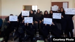 Iranian teachers protest in Alborz Province on March 4. They are holding signs expressing dissatisfaction with hyperinflation and low wages. 