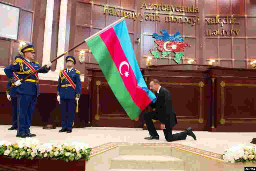 Aliyev kisses his country's flag as part of his inauguration ceremony.