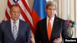 France -- U.S. Secretary of State John Kerry (R) gestures as he stands with his Russian counterpart Sergey Lavrov, before their meeting in Paris, June 5, 2014. 