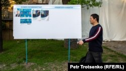 Қазақстан президенттігіне кандидаттар Қасым-Жомарт Тоқаев пен Амангелді Таспиховтың сайлау жарнамалары ілінген жерден өтіп бара жатқан адам. Алматы, 13 мамыр 2019 жыл.