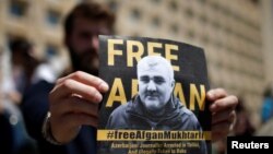 Участник демонстрации в Тбилиси держит плакат с призывом освободить азербайджанского журналиста Афгана Мухтарлы, похищенного из Грузии. 31 мая 2017 года.