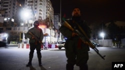 Afghan security forces block a road as they stand guard near the security perimeter set up around the Serena Hotel in downtown Kabul late overnight on March 20-21, when four gunmen killed at least nine people there.