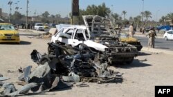 Destroyed vehicles at the site of a car bomb set off by a suicide attacker in the center of Baghdad as part of a wave of deadly attacks across Iraq. 