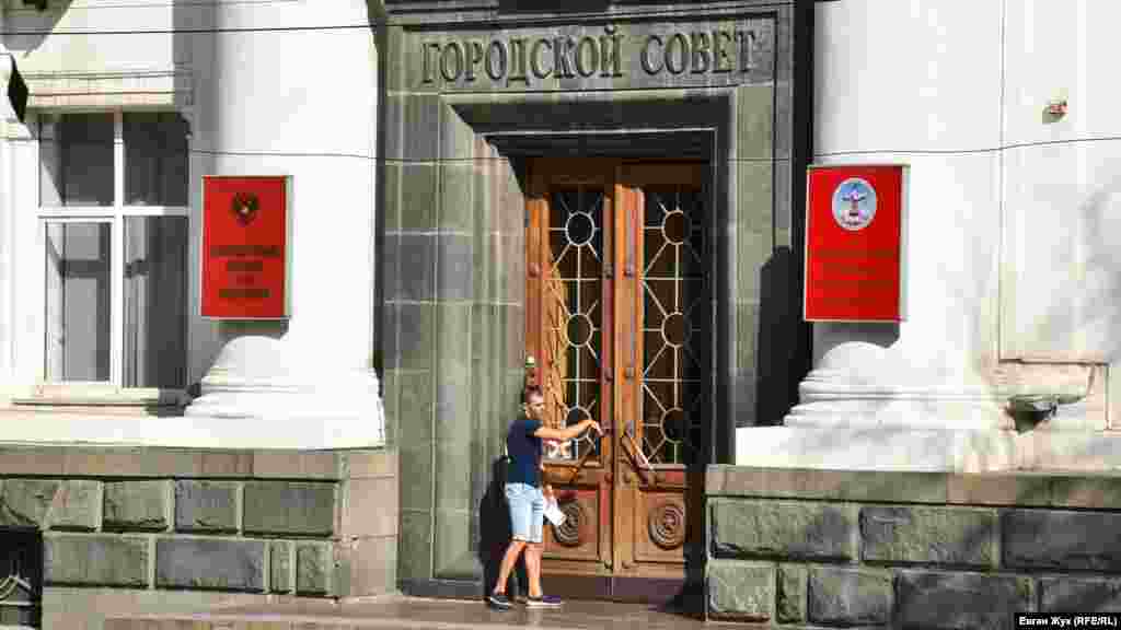 Мужчина без защитной маски входит в здание российского парламента Севастополя