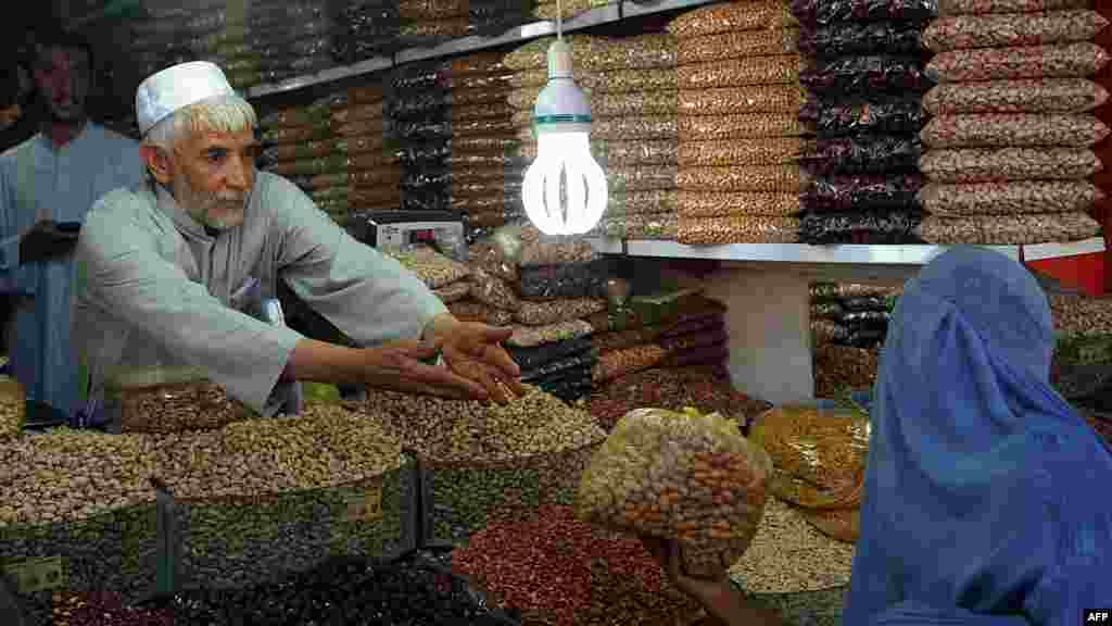 Ramazan ərəfəsində bazarlıq edən əfqan qadın. Herat, Afghanistan. (AFP/Aref Karimi)