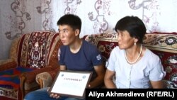 Рысбек Досан с сертификатом акима и мать юноши Тансык Уатхан. Алматинская область, 5 августа 2015 года.