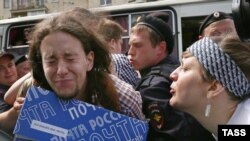 Сторонница ортодоксального христианства плюет в лицо защитнице прав геев во время митинга у здания Госдумы. Москва, 11 июня 2013 года. 