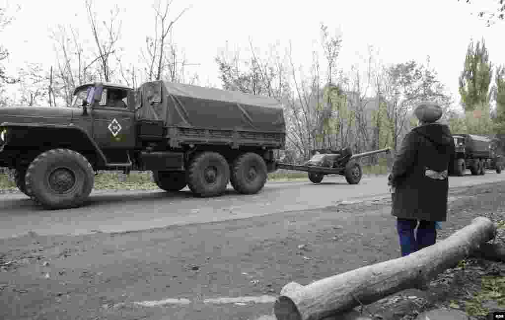 Жінка пропускає колону проросійських бойовиків, які відводять артилерію калібром до 100 мм від лінії зіткнення в районі села Зелене, Донецької області, 28 жовтня 2015 року