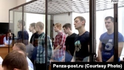 Seven men who received sentences of six to 18 years appear in court in the Volga Military District Court in Russia. 