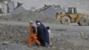 An Afghan woman and her children walk near an open-cast mine in the Turkham Nangarhar region of Afghanistan bordering Pakistan. Manufacturing, mining, and Afghanistan's agricultural sectors would be the most likely areas of investment. 