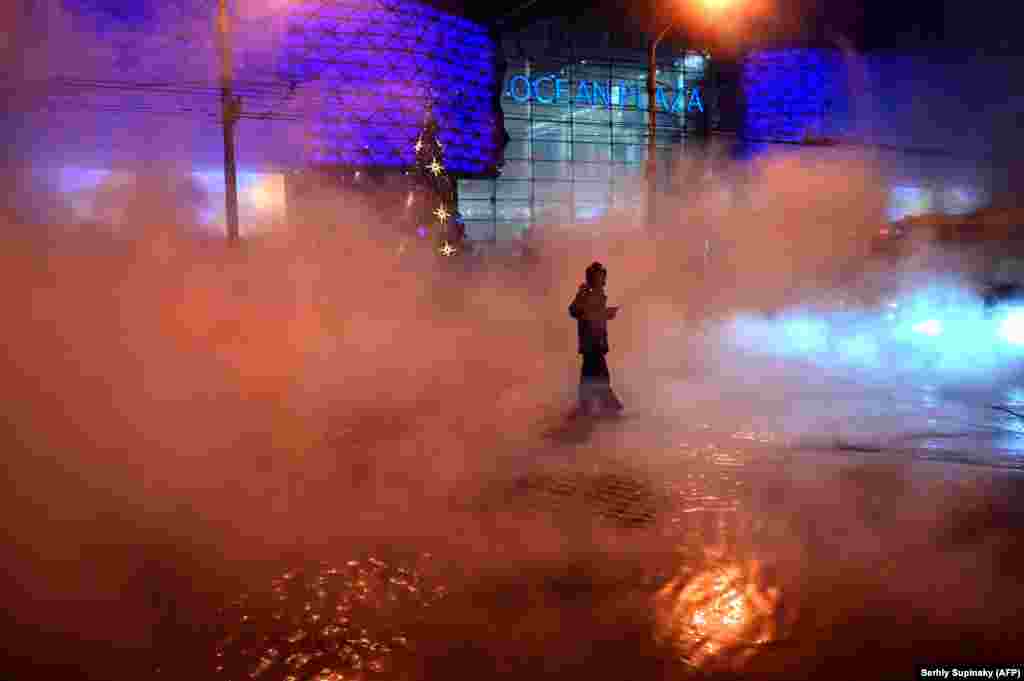 A Ukrainian emergency worker attends the scene after a hot-water pipe burst at a shopping mall in central Kyiv on January 13. (AFP/Sergei Supinsky)