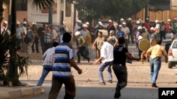 Supporters (background) and opponents of Egyptian President Muhammad Morsi clash in the coastal city of Alexandria on June 28.