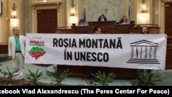 Senatorii Vlad Alexandrescu și Mihai Goțiu poartă o pancardă cu un mesaj sugestiv: „Roșia Montana” în Unesco.