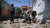 Afghan security officials inspect the scene of a bomb blast near a voter-registration center in Jalalabad on April 29.