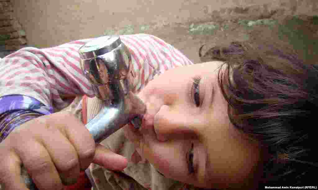 A child drinks from a tap at a camp for displaced people in Kabul.