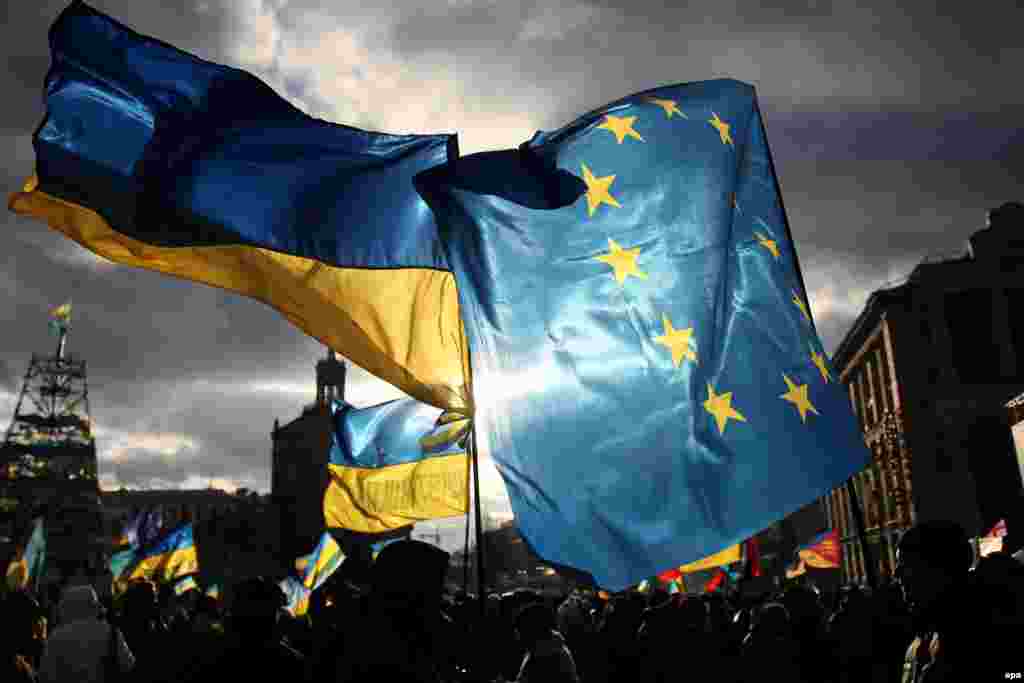 Two men hold EU and Ukrainian flags during a pro-European rally on Independence Square in Kyiv. (epa/Zurab Kurtsikidze)