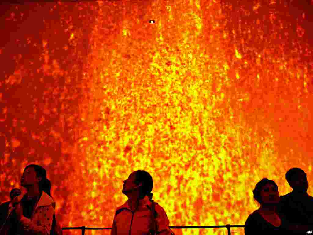 Наведнікі глядзяць на здымкі вывяржэньня вулькану ў ісьляндзкім павільёне ўсясьветнай выставы ў Шанхаі. 