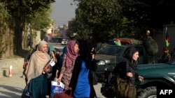 Afghan women students who were trapped inside the premises during an attack by militants are escorted by Afghan police at the end of a nearly 10-hour raid at the American University of Afghanistan in Kabul in August 2016.