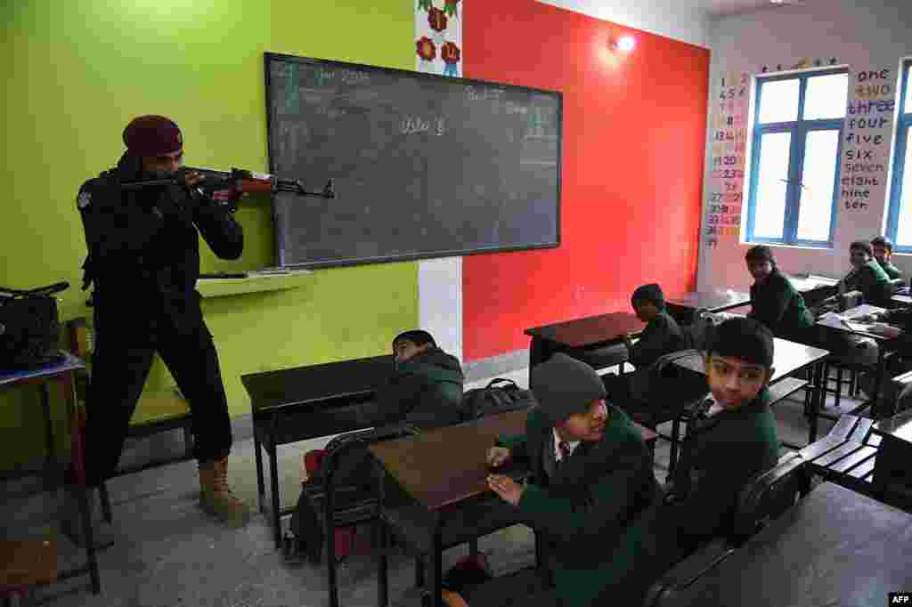 A member of Pakistan's Elite Police Force takes part in a drill to fight militants at a school in Peshawar on January 28.