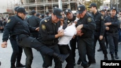 Полицейлер оппозиция шеруіне қатысқан адамды әкетіп барады. Баку. 2013 жылдың қазаны.