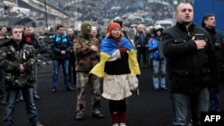 Үкіметке қарсы шеруге қатысушылар Киевтің Тәуелсіздік алаңында Украина гимнін шырқап тұр. 22 ақпан 2014 жыл.