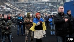 Участники антиправительственных протестов поют гимн на Майдане Незалежности в Киеве. 22 февраля 2014 года.