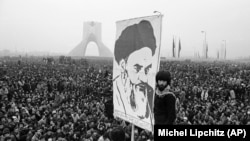 Демонстрант с портретом Рухоллы Хомейни во время антишахской революции в центре Тегерана, 1978 год.