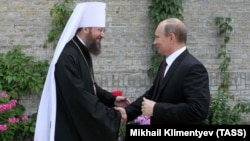 Metropolitan Antony of Borispol, chancellor of the Ukrainian Orthodox Church, Moscow Patriarchate (left), and Russian President Vladimir Putin shake hands in Kyiv in July 2013.