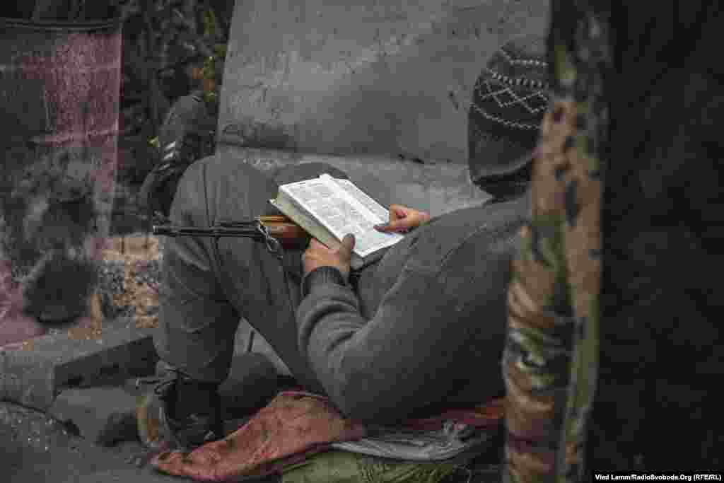 Український військовий читає біблію під час чергування на бойовій позиції поблизу Авдіївки, 11 листопада 2015 року
