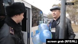 Көк шар ұстаған ер адам полиция машинасының жанында тұр. Астана, 22 наурыз 2018 жыл.