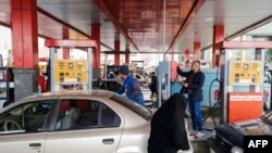 Iranian drivers refuel their vehicles at a gas station, on the first anniversary of the nuclear agreement, in the capital Tehran on Jaunary 14, 2017. - The first anniversary, of the nuclear deal between Iran and six powers, that lifted a large part of int