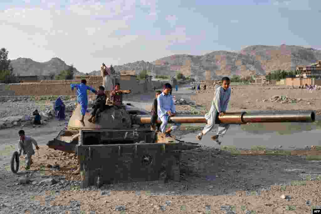 Афганістан – Діти граються на уламках старого радянського танка на околиці Джалалабада, 16 жовтня 2013 року